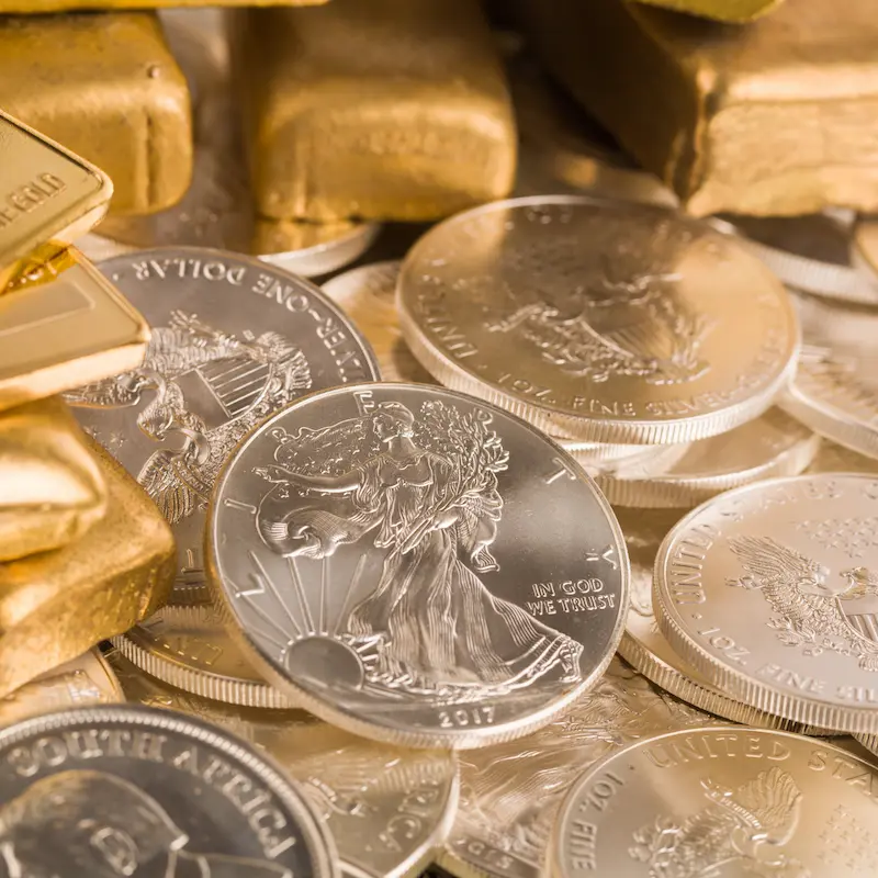 Gold And Silver American Eagle Coins stacked in a pile.